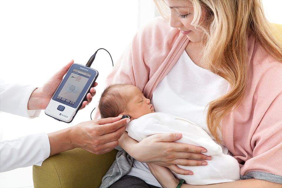 Sleeping baby being held by mother and screened using EasyScreen.