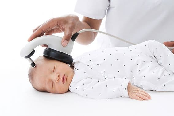 Sleeping baby being screened with MB11 BeraPhone by audiologist.